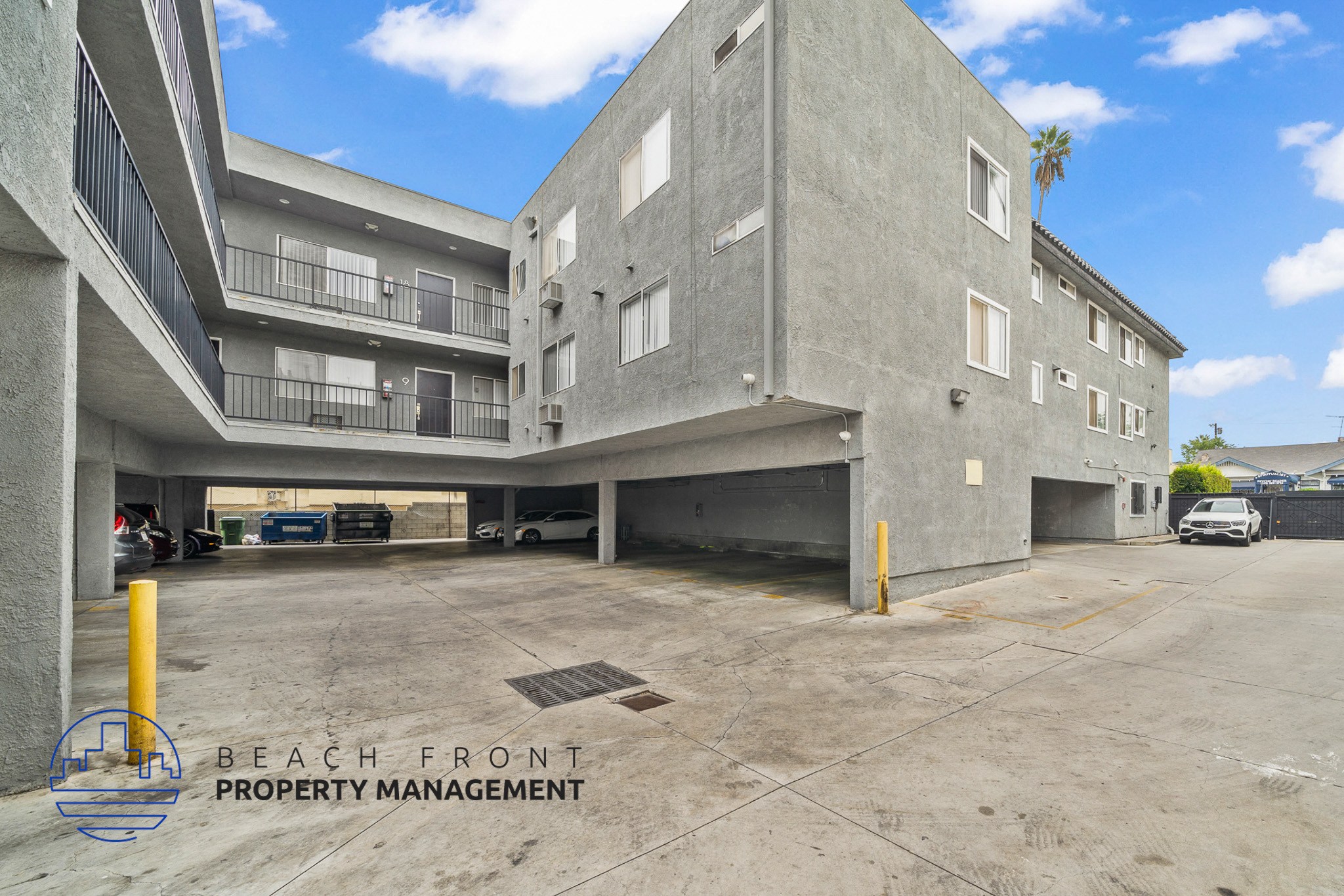 A parking lot with a building in the background and a sign that says Beach Front Property Management.